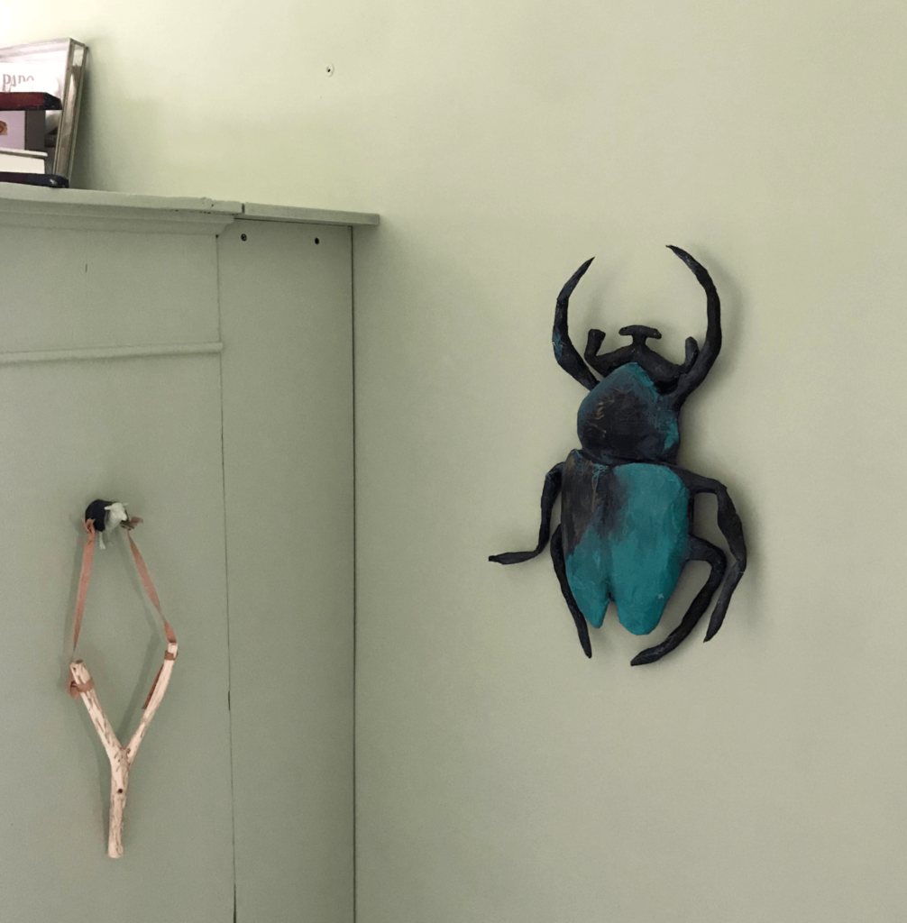 een beetle van papiermache aan de muur in een kinderkamer