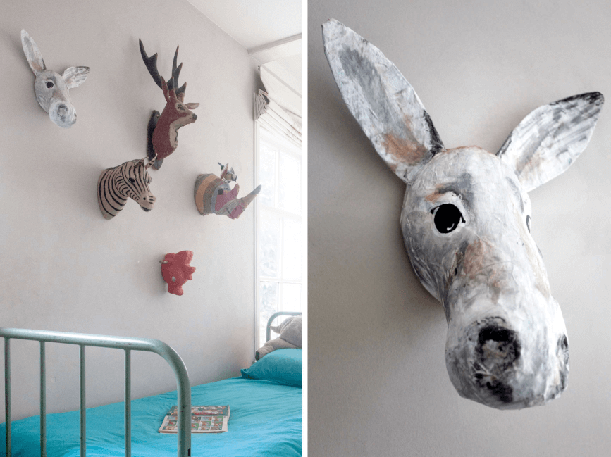 een papiermache ezel dierenkop aan de muur tussen andere dieren
